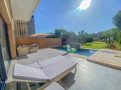 a patio with a pool with a table and a swing at Argan Golf Villa 4-bed Marrakech in Marrakech