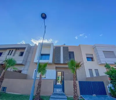 a building with palm trees in front of it at Argan Golf Villa 4-bed Marrakech in Marrakech