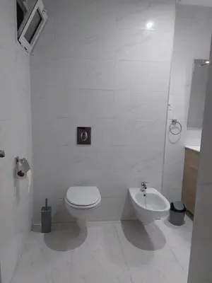 a white bathroom with a toilet and a sink at Centre Marrakech, Chic et Calme in Marrakech
