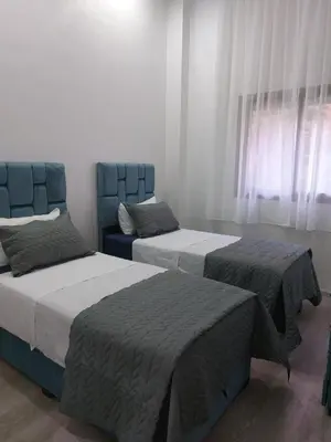 a bedroom with two beds and a blue chair at Centre Marrakech, Chic et Calme in Marrakech