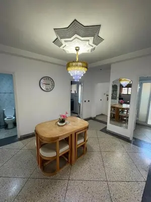 a dining room with a table and a chandelier at Luxury Apartment in Marrakesh in Marrakech