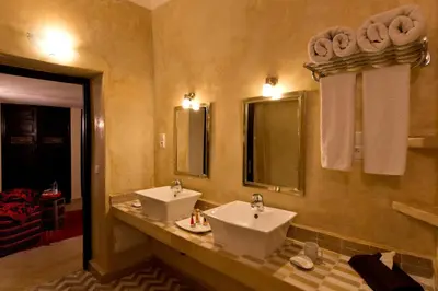 a bathroom with two sinks and two mirrors at Riad Signature in Marrakech