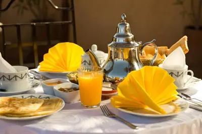 a table topped with plates of food and orange juice at Riad Signature in Marrakech