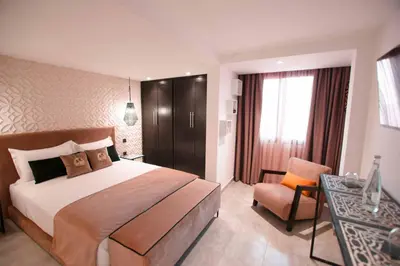 a bedroom with a bed and a desk and a chair at Riad La Petite Majorelle in Marrakech