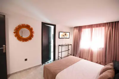 a bedroom with a bed and a mirror and a window at Riad La Petite Majorelle in Marrakech