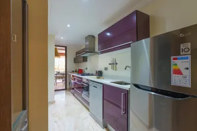 a kitchen with stainless steel appliances and purple cabinets at Luxueux 138 m2 avec piscine in Marrakech