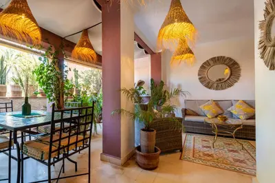 a living room with a table and a couch at Luxueux 138 m2 avec piscine in Marrakech