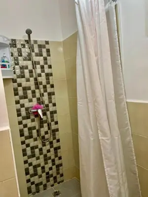 a shower with a shower curtain in a bathroom at Belle Appartement familiale,couple marié in Marrakech