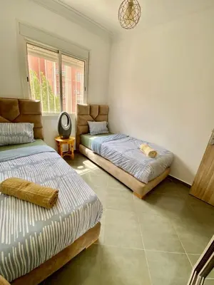 a bedroom with two beds and a window at Belle Appartement familiale,couple marié in Marrakech