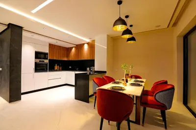 a kitchen with a dining table and red chairs at Duplex de luxe, piscine sauna in Marrakech