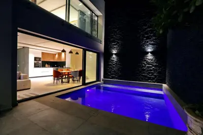 a swimming pool in a house with purple lighting at Duplex de luxe, piscine sauna in Marrakech