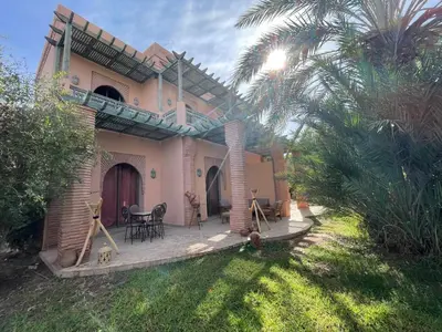 a house with a patio with a table and chairs at Au Riad de la Palmeraie - Marrakech in Marrakech