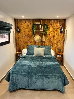 a bedroom with a large bed with a green blanket at Dar L'hna in Marrakech