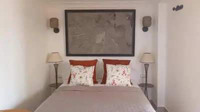a bedroom with a bed with two lamps and a painting at Dar L'hna in Marrakech