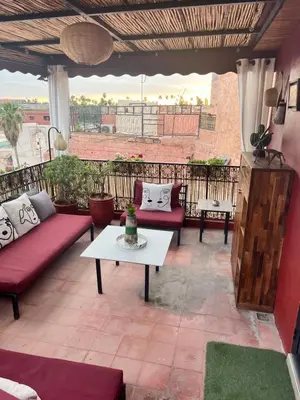 a patio with red couches and a white table at Dar L'hna in Marrakech