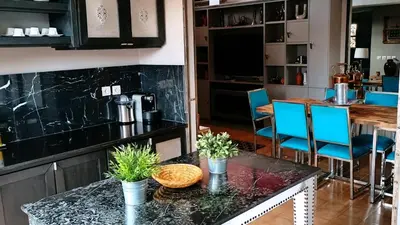 a kitchen with a black counter top and blue chairs at Dar L'hna in Marrakech