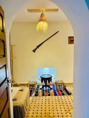 a living room with a table and a chandelier at Riad Rayan in Marrakech