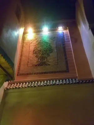 a painting of a tree on a wall with lights at Riad Rayan in Marrakech