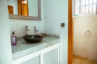 a bathroom with a sink and a mirror at villa 5 chambres pour famille avec piscine & parking in Marrakech