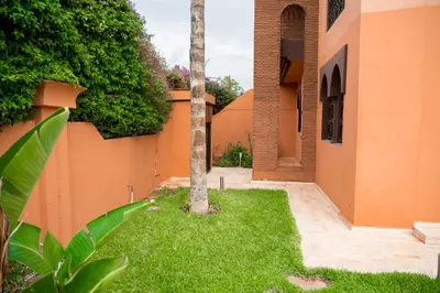 a palm tree in a yard next to a building at villa 5 chambres pour famille avec piscine & parking in Marrakech