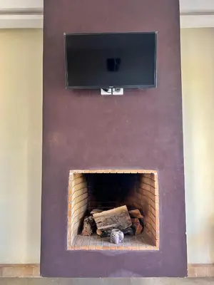 a fireplace with a flat screen tv above it at Luminous apartment with pool view in Marrakech