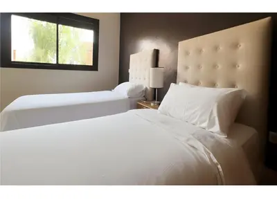 a bedroom with two white beds and a window at Luminous apartment with pool view in Marrakech