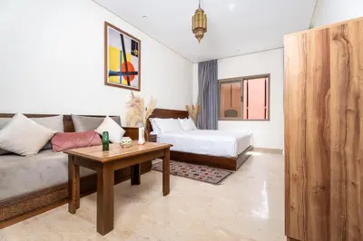 a bedroom with a bed and a couch and a table at Dar Nourdha in Marrakech