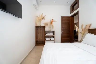 a bedroom with a white bed and a flat screen tv at Dar Nourdha in Marrakech