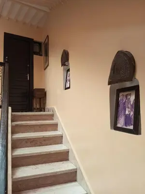 a set of stairs with a door and pictures on the wall at Riad Lahbiba in Marrakech