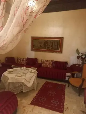 a living room with a table and red couches at Riad Lahbiba in Marrakech
