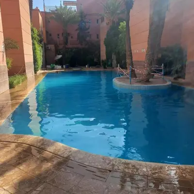 a large swimming pool with blue water in a building at Riad Lahbiba in Marrakech