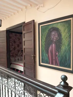 a painting of a woman on a wall next to a bedroom at Riad Lahbiba in Marrakech