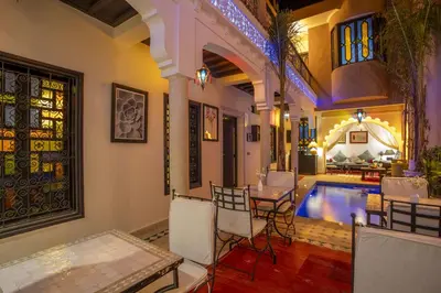 a room with a pool and a table and chairs at Riad Tala in Marrakech