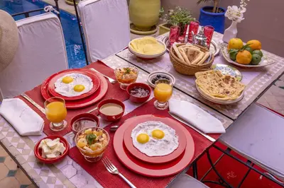a table with plates of eggs and other food on it at Riad Tala in Marrakech