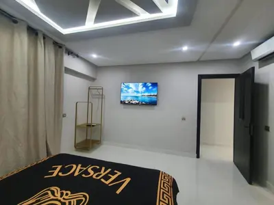 a bedroom with a bed and a television on the wall at Kech vacations Friendly 2 Bedroom Luxury apartment in Marrakech