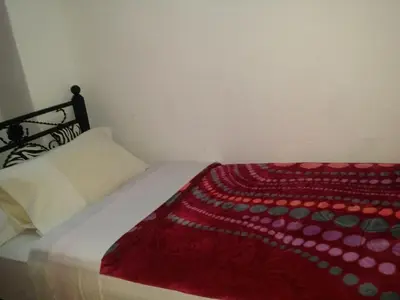a bed with a red blanket on top of it at Riad Espagne in Marrakech