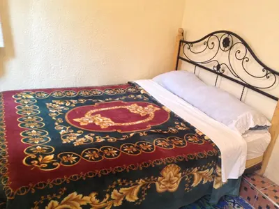 a bed with a colorful blanket on top of it at Riad Espagne in Marrakech