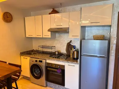 a kitchen with a stainless steel refrigerator and a stove at Appartement pour les familles , superbe vue sur la piscine in Marrakech