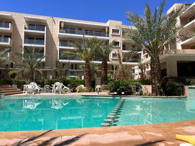 a swimming pool in front of a building at Appartement pour les familles , superbe vue sur la piscine in Marrakech