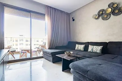 a living room with a couch and a table at Appartement pour les familles , superbe vue sur la piscine in Marrakech