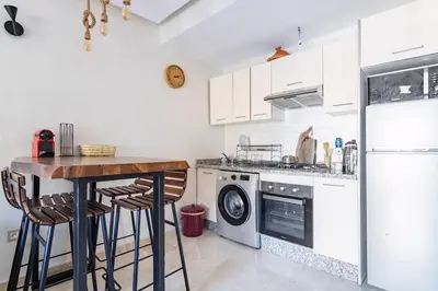 a kitchen with a table and a stove and a refrigerator at Appartement pour les familles , superbe vue sur la piscine in Marrakech