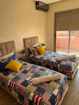 two beds sitting next to each other in a room at Bel appartement à louer à Marrakech targa in Marrakech
