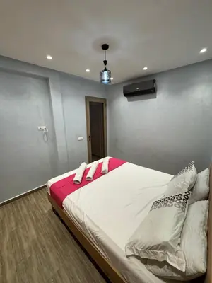 a bedroom with a large bed with red and white pillows at Bel appartement à louer à Marrakech targa in Marrakech