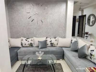 a living room with a couch and a clock on the wall at Luxury villa near airport & City center in Marrakech