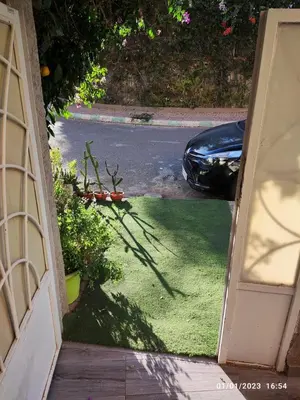 an open door to a driveway with a car parked at Luxury villa near airport & City center in Marrakech