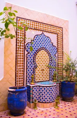 three blue vases sitting on a tile floor with a shrine at RIAD LAICHI in Marrakech