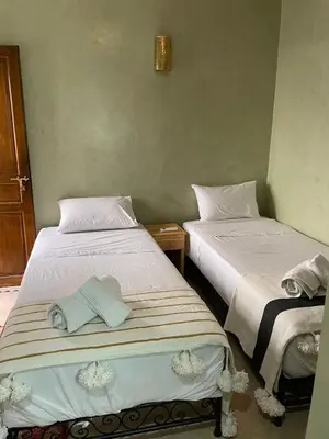 two beds sitting next to each other in a room at RIAD LAICHI in Marrakech