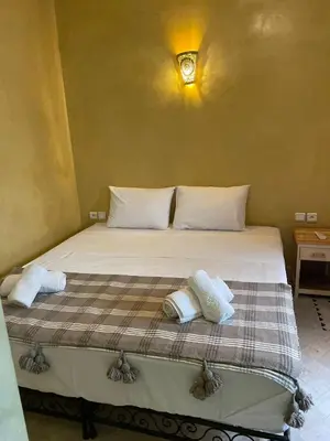 a bed in a room with two pillows on it at RIAD LAICHI in Marrakech
