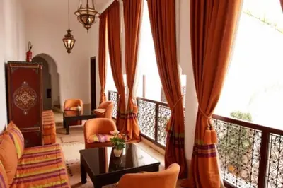 a living room with orange curtains and a large window at Riad Dar Rania Marrakech Médina Jemaa El Fna in Marrakech