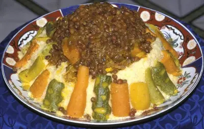 a plate of food with meat and vegetables on a table at Riad Dar Rania Marrakech Médina Jemaa El Fna in Marrakech